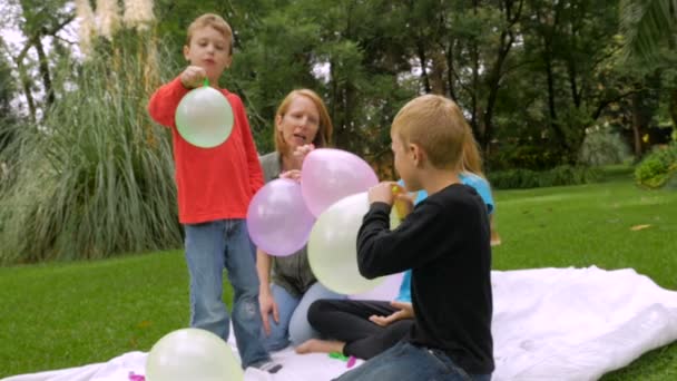 Children let their balloons fly away and one hits the camera - slowmo