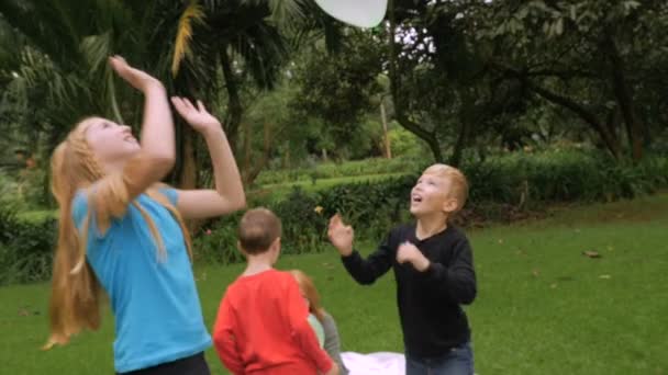 Una familia comienza un simple juego de golpear globos en el aire - slow mo — Vídeo de stock