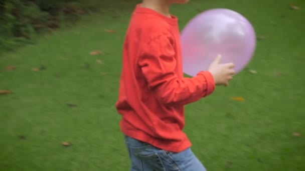 A young boy brings a balloon to his mother outside in a yard - slow mo — Αρχείο Βίντεο