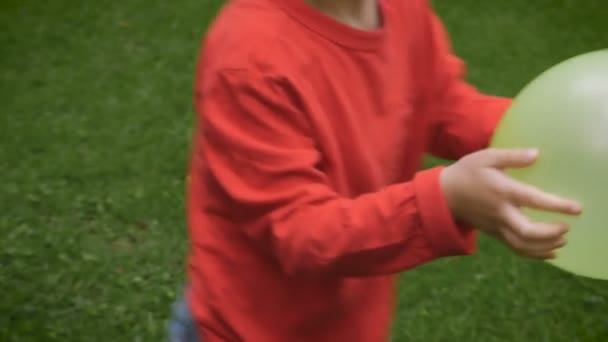 Two young boys and a mother playing with balloons outside in a yard - slowmo — Stock video