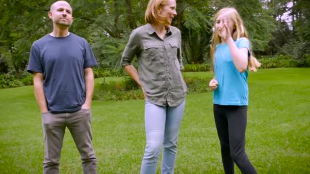 A family of five standing around in the grass barefoot - slowmo steadicam — ストック動画