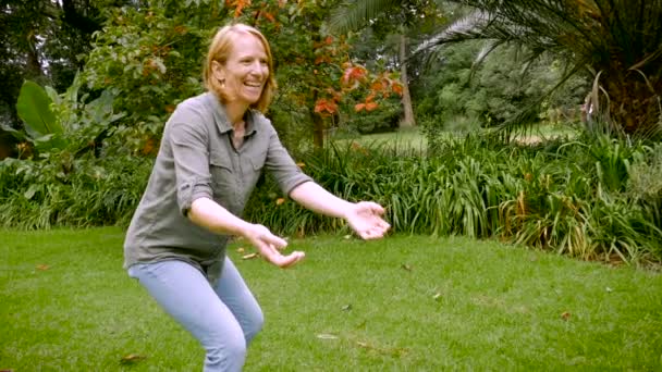 Un petit garçon court vers sa mère et elle le soulève et le tourne autour — Video