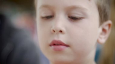 Bir masada oturan bir oyuncakla oynarken küçük şirin bir çocuk