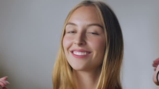 An attractive young blond woman plays with her healthy hair in slow mo — Stock Video