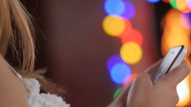 Tatillerinde şömine önünde bir kadın tarafından kullanılan telefon yakın çekim