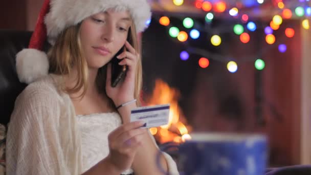 En kvinna kallar i sin beställning med kreditkort via en smart telefon - dolly — Stockvideo