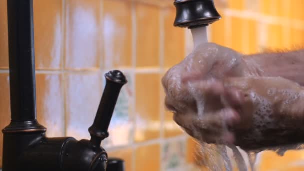 Мужчина моет руки с мылом под краном в медленном темпе - закрыть — стоковое видео