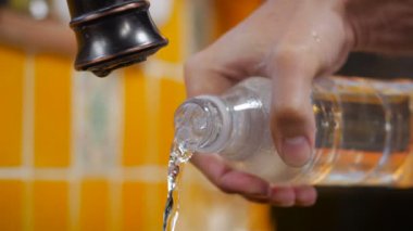A yakın çekim plastik şişeden su dökme bir adamın