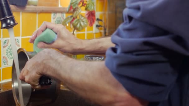 Ein Mann wäscht einen Edelstahltopf mit einer schnellen Verschlusszeit - Dolly — Stockvideo