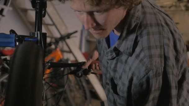 Tusenåriga man cykel mekaniker justerar bakväxeln på en mountainbike — Stockvideo