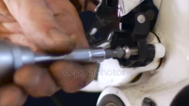 Close up of a man loosening a derailleur on a bike with a screw driver — Stock Video