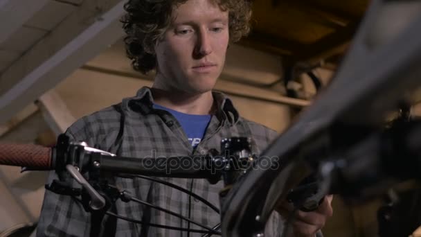 A millennial man bike mechanic adjusting cables and shifters on bike — Stock Video