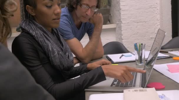 Une femme afro-américaine dirige une réunion d'affaires avec son équipe millénaire 