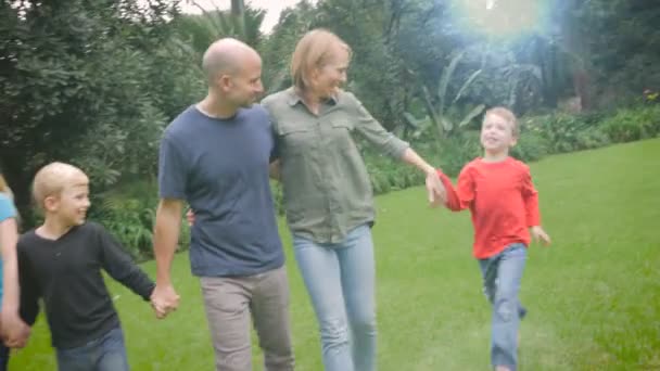 小さな男の子が彼らを一緒に歩く彼の家族に参加する母親に駆け寄る — ストック動画