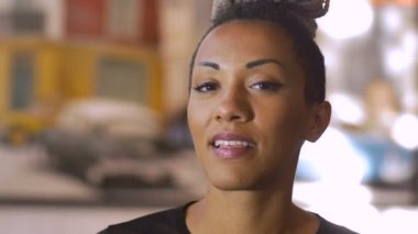 Çekici bir Afro-Amerikan bin yıllık kadın gülümsüyor ve kameraya benziyor