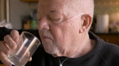 Oksijen maskesi giyen bir yaşlanma bebek boomer kıdemli cam içecekler