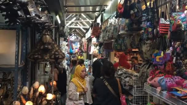Uma mulher em um hijab amarelo está comprando em um mercado interno ocupado — Vídeo de Stock
