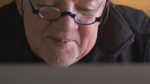 Μια ελκυστική ηλικιωμένους ανώτερος άνθρωπος διαβάζοντας δυνατά από δικός του laptop — Αρχείο Βίντεο