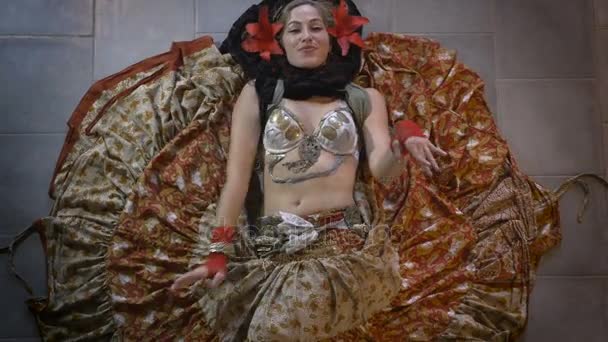 Μια γυναίκα χορεύτρια της κοιλιάς για τον καθορισμό του δαπέδου με μεγάλη φούστα χορού — Αρχείο Βίντεο
