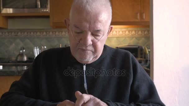 Un uomo anziano che prende pillole dal suo flacone con l'ossigeno — Video Stock
