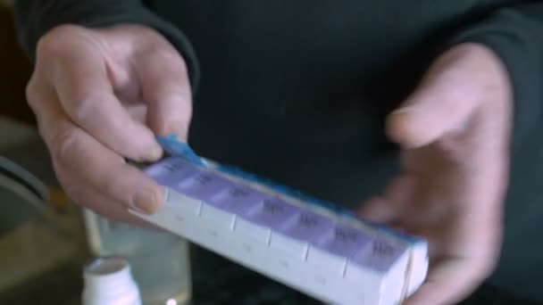 Egy idős ember vesz gyógyszerek a napi tabletta-tervező — Stock videók
