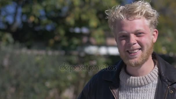 Um tímido, atraente loiro cabelo millennial homem rindo e falando — Vídeo de Stock