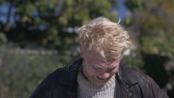 Młoda blond człowieka z brodą, śmiejąc się i uśmiechając się do kamery — Wideo stockowe