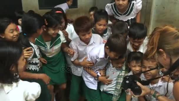 Eine Frau zeigt einer Gruppe burmesischer Kinder ihre Kamera in einem Klassenzimmer — Stockvideo