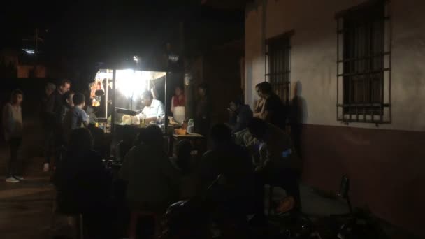 Människor samlas runt en taco monter på natten i Mexiko — Stockvideo