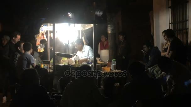 Gente comiendo en un puesto de tacos al aire libre por la noche — Vídeos de Stock