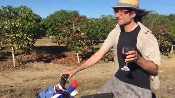 Un uomo in bicicletta applaude alla macchina fotografica con un bicchiere di vino rosso — Video Stock