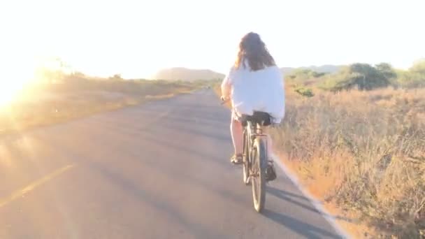 Pov der Kamera folgt einer schönen blonden Frau auf einem Fahrrad — Stockvideo