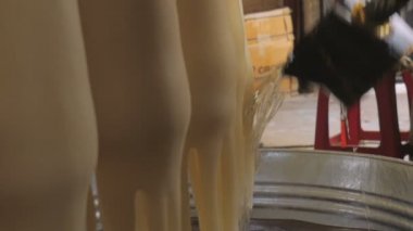 Bir fabrikada el yapımı olmak mum üzerinde sıvı balmumu dökülür
