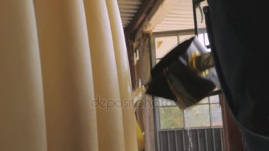 Yavaş çekimde bir fabrikada mum üzerinde sıcak balmumu dökülen bir adam