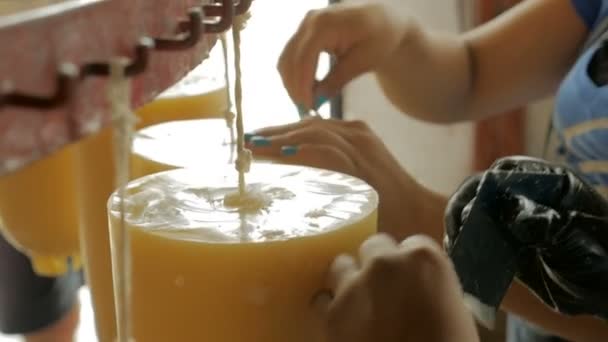 Una mano pulisce con cura lo strumento utilizzato per la fabbricazione di candele fatte a mano in cera d'api — Video Stock