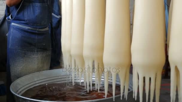 Worker pouring hot wax on hand made candles dripping into a tub — Stock Video