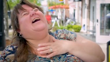 Kahkahalarla gülmekten neşeli dostça mutlu gülümseyen düzgün vücutlu kadın