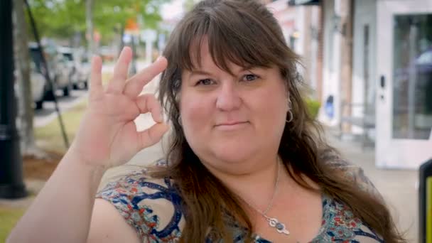Happy smiling plus sized woman gives the a-ok outside — Stock Video