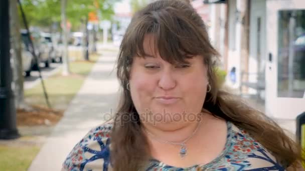 Саші повна фігурна жінка на міському тротуарі кажучи висловлюючи сумніви — стокове відео