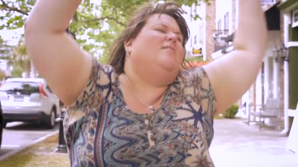 Erg blij overgewicht vrouw stedelijke dansen en jammin in de straten van een stad — Stockvideo