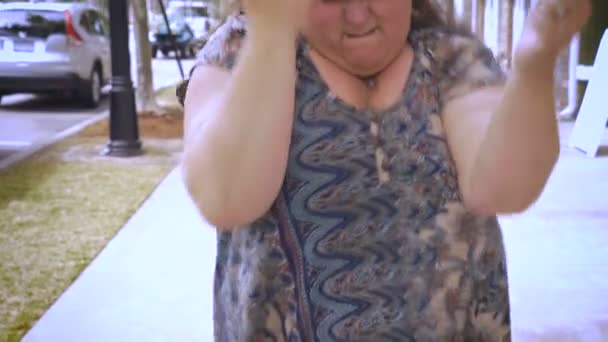 Egy boldog túlsúlyos nő táncol a járdán egy kereskedelmi város kerületében — Stock videók