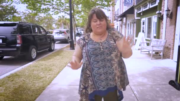 A full bodied woman dancing on a sidewalk in a city in slow motion — Stock Video