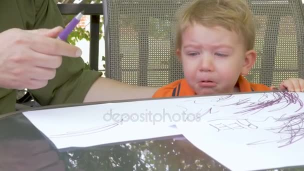 Un bambino con una faccia triste che aspetta che suo padre gli dia una penna. — Video Stock