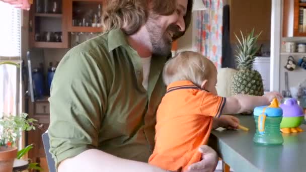Uczucia ojciec trzymający syna na jego kolanach, podczas gdy on jest jedzenie zdrowej żywności — Wideo stockowe
