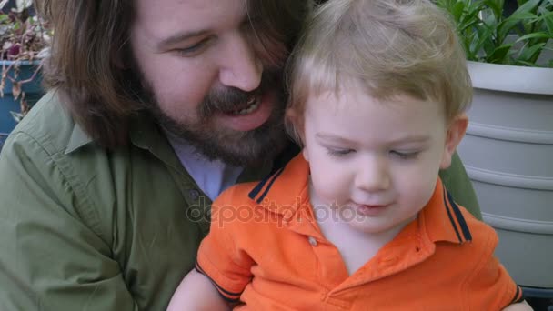 Un padre enseñando a su pequeño bebé a usar una aplicación para tabletas o tecnología de video — Vídeos de Stock