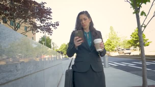 Professional millennial businesswoman on mobile phone walking down city street — Stock Video