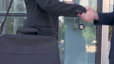Modern ofis binası dışında el sıkışan iki iş adamları, yakın çekim