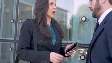 Bir kadın iş yürütme onun erkek arkadaşı bir şey akıllı telefonunu gösterir