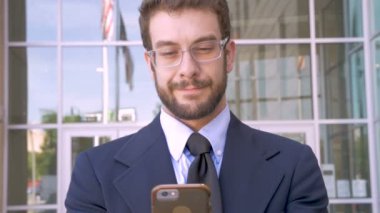 Yakışıklı adam akıllı telefon teknoloji uygulaması ile kamera ve gülümsüyor görünüyor