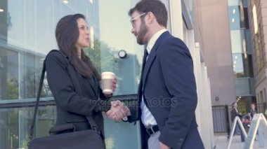 Ağır çekimde bir modern ofis dışında el sıkışan iki iş adamları